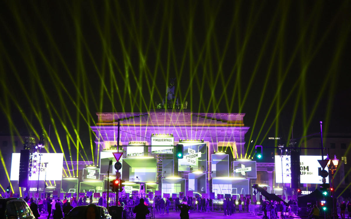 Visitors watch a light show at the festival for freedom on the eve marking the 35th anniversary of the fall of the Berlin Wall on November 9, 1989 at the Brandenburg Gate in Berlin. (Reuters)