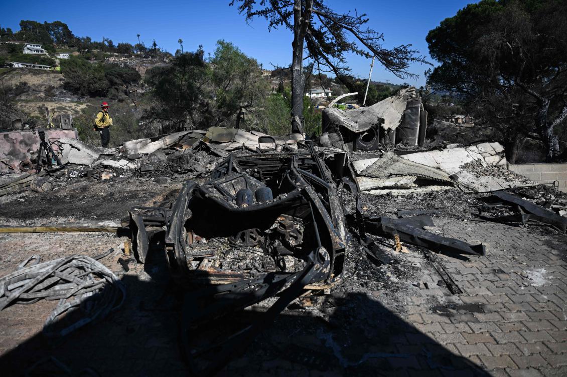 A burned out vehicle sits in the driveway of a home destroyed by a wind driven wildfire on West Highland Drive during the Mountain Fire in Camarillo, California on November 8, 2024. (AFP)