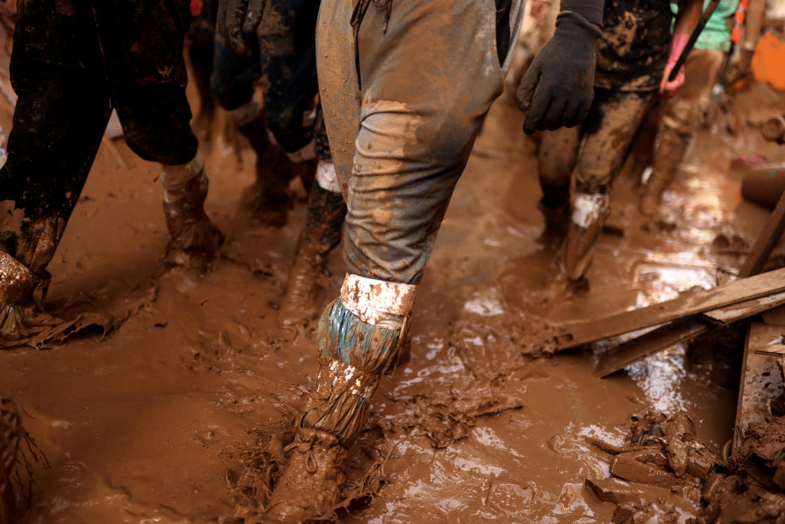 Volunteers walk on a mud-covered street as they get ready to help in the aftermath of floods caused by heavy rains in Paiporta, near Valencia, Spain, November 5, 2024. (Reuters)