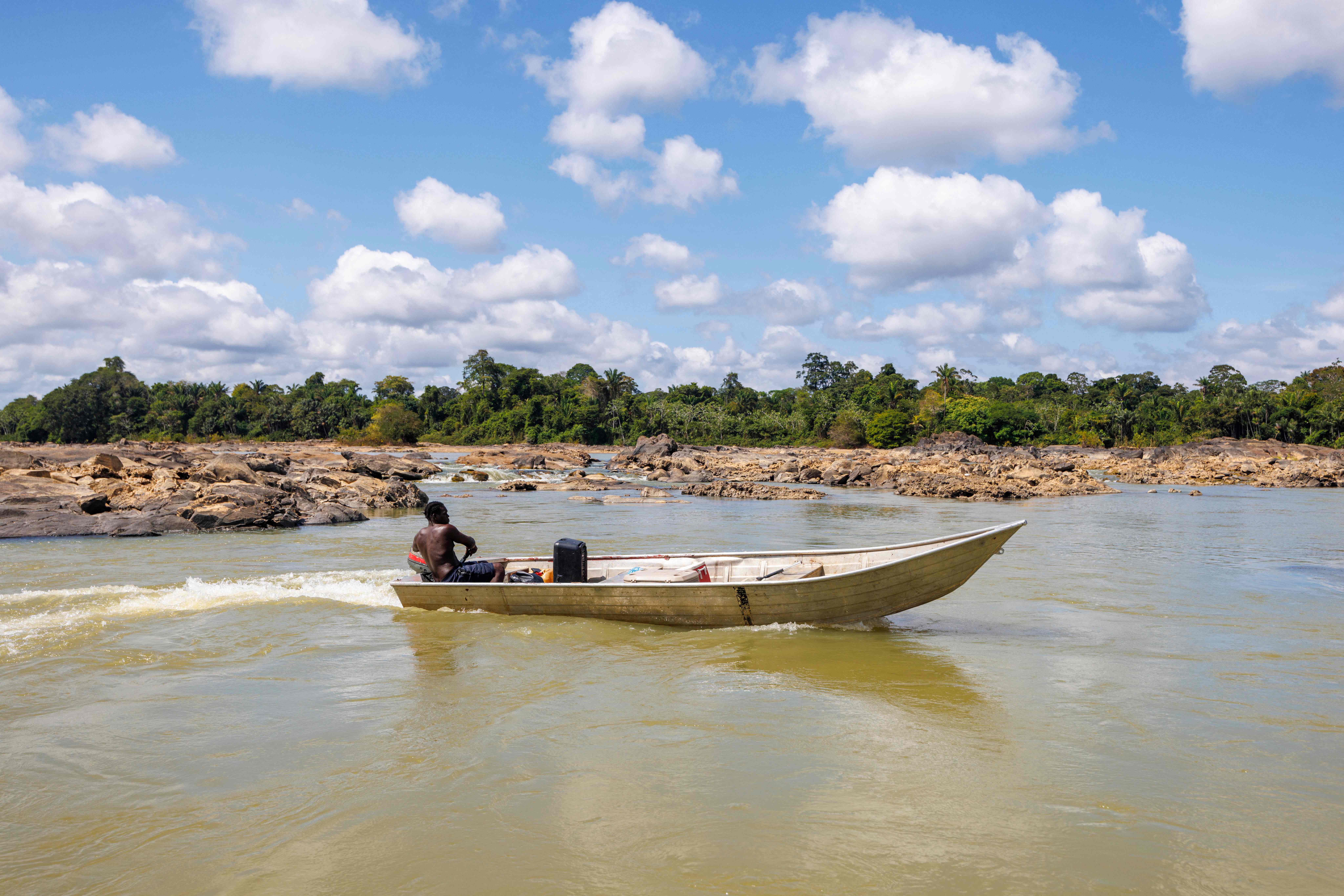This photograph taken on November 6, 2024, show boats navigating the Maroni river affected by droughts which hinder navigation, near the town of Apatou, in French Guiana. (AFP/File)