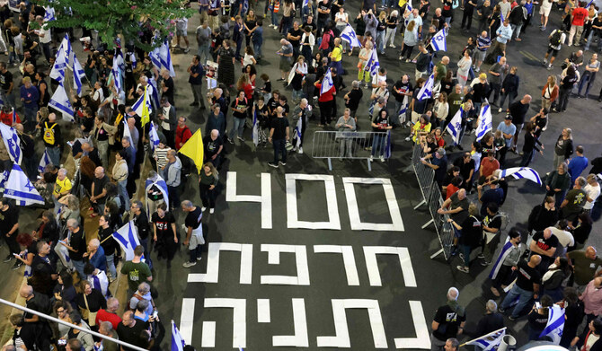 A sign reading in Hebrew, "400 days disgrace Netanyahu" (Israeli prime minister) is displayed on the pavement during a rally demanding the return of Israeli hostages kidnapped since the October 7 attack by Hamas in southern Israel, in Tel Aviv, on November 9, 2024, amid the ongoing war between Israel and the Hamas group in the Gaza Strip. (AFP)