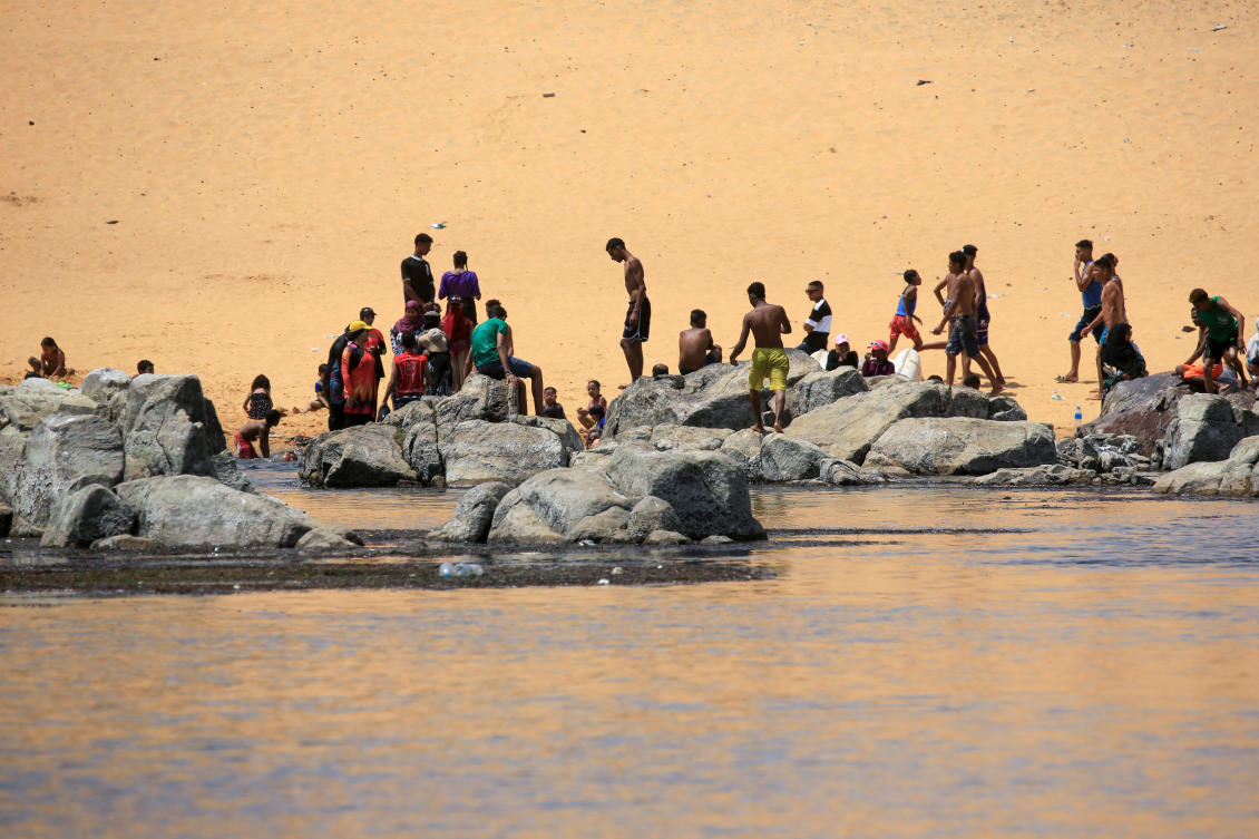 Sudanese who fled the war in their country cool off on the banks of the Nile river in the Egyptian city of Aswan. (File/AFP)