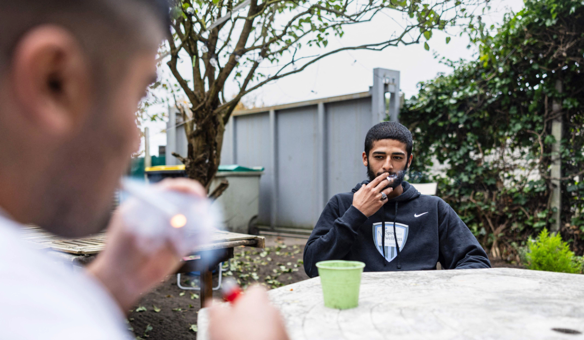 Osama Ahmed, a 20-year-old Syrian man smokes at the house of the association "LaMargelle Calais" where he lives since his father disappeared when their boat sank on the night of October 23, 2024, in Calais, northern France on November 7, 2024. (AFP)