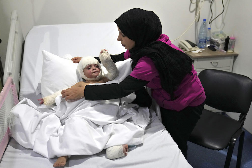 Ivana Skakye, who suffered third-degree burns following an Israeli airstrike last September, is tended by her mother Fatima Zayoun as the two-year old gets treated at the Lebanese hospital Geitaoui in Beirut on Oct. 29, 2024. (AP)