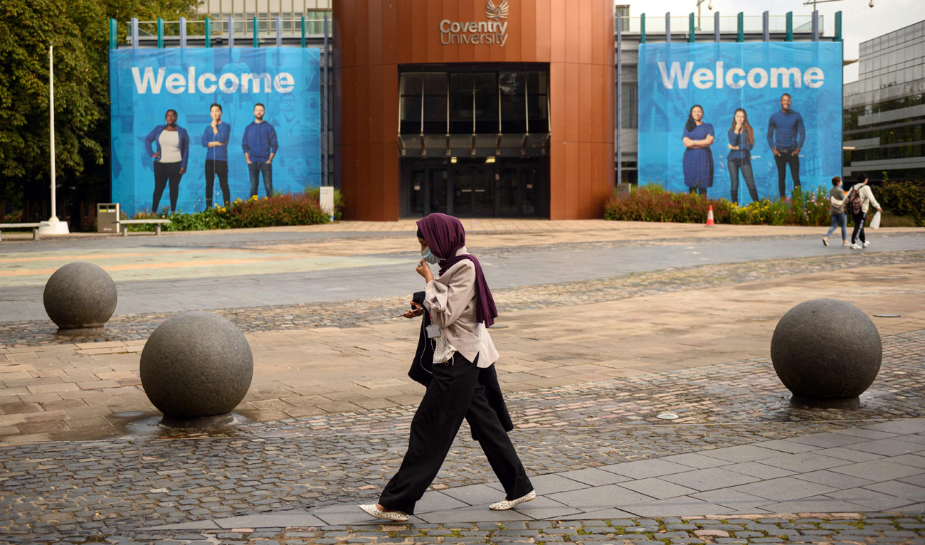 A woman walks through University Square past Coventry University’s Alan Berry Building at the beginning of the new academic year, at Coventry University, in Coventry, central England on September 23, 2020. (AFP/File)