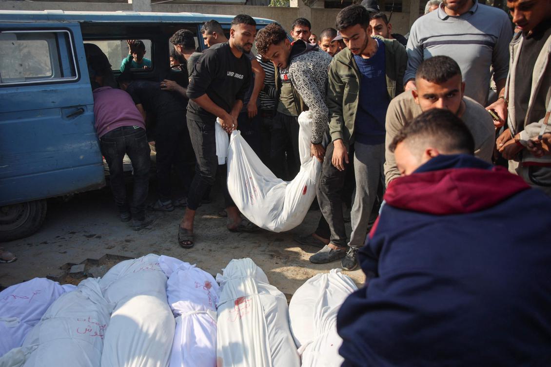 Palestinians unload from a van, the bodies of a victims killed in Israeli strikes, at a cemetery in Jabalia in the northern Gaza Strip on November 10, 2024.(AFP)
