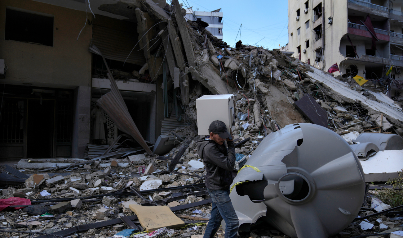 A man carries a safe box after he pulls it out of a destroyed building that was hit by Monday’s Israeli airstrike in Dahiyeh in the southern suburb of Beirut. (AP)