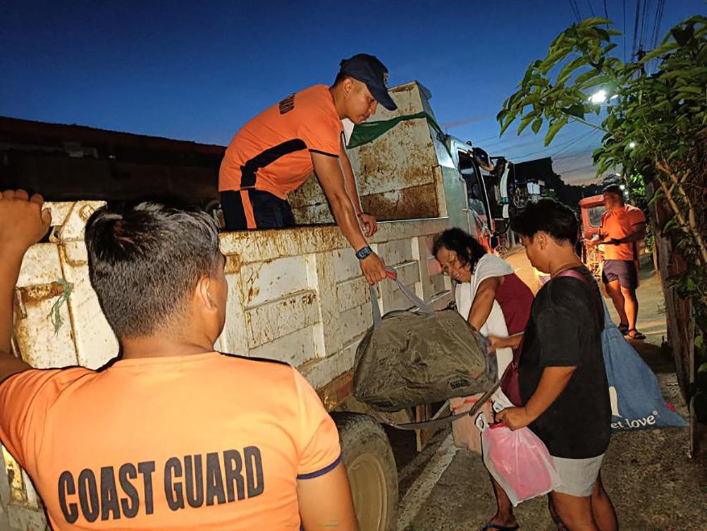 Philippine Coast Guard personnel evacuate residents during an operation in Virac town, Catanduanes province ahead of the arrival of Typhoon Many-yi. (Philippine Coast Guard/AFP)