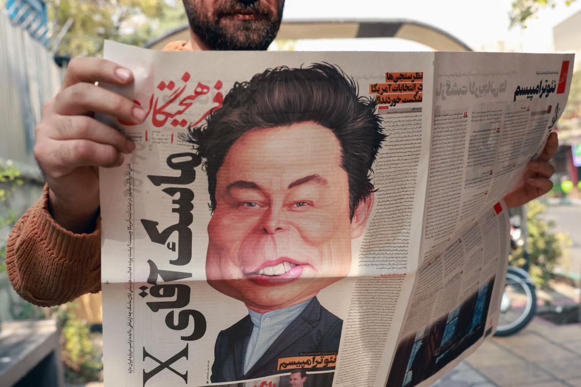 An Iranian man holds a copy of Iran's Farhikhtegan daily newspaper with a cartoon drawing of Elon Musk on its front-page, as Iranian media referred to a reported meeting between Tehran's ambassador to the United Nations and the tech billionaire earlier this week, outside a news stand in Tehran on November 16, 2024. (AFP)