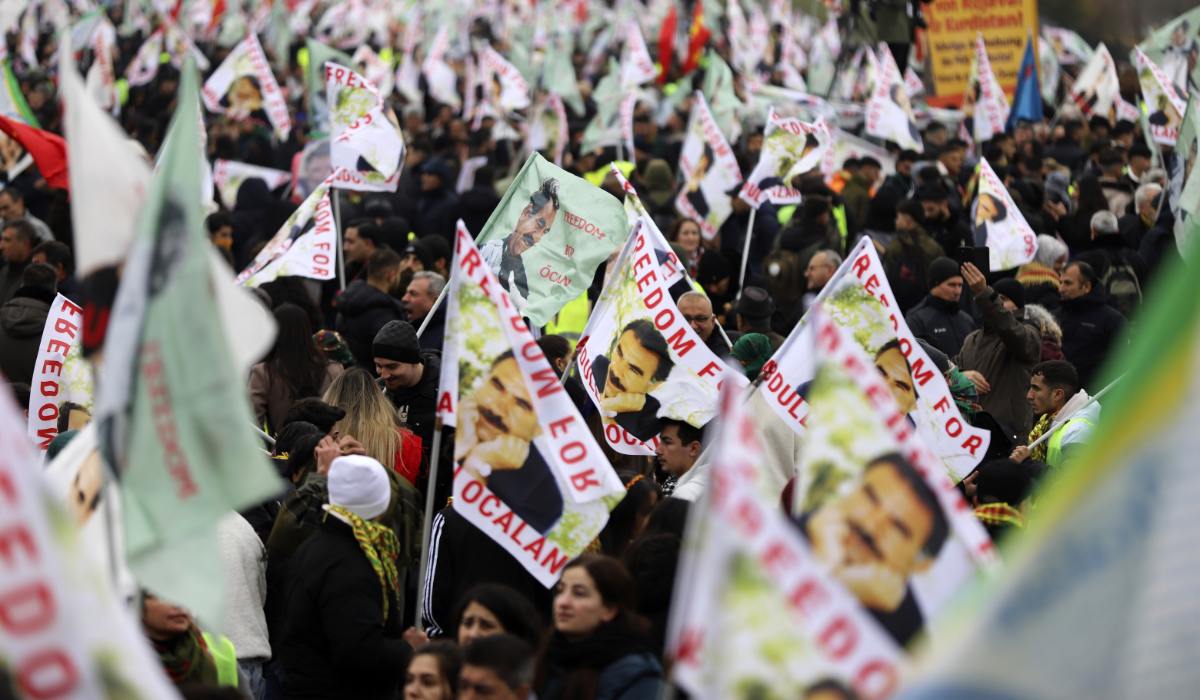 People hold up flags as they take part in the rally held by the Kurdish organization Kon-Med in Cologne, Germany, Saturday Nov. 16, 2024. (AP)