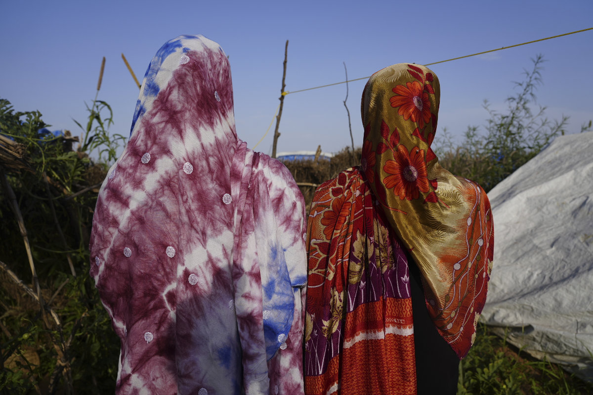Women who fled war in Sudan and requested anonymity because they feared retribution after reporting sexual exploitation, walk in a refugee camp in Adre, Chad, on Oct. 5, 2024. (AP)