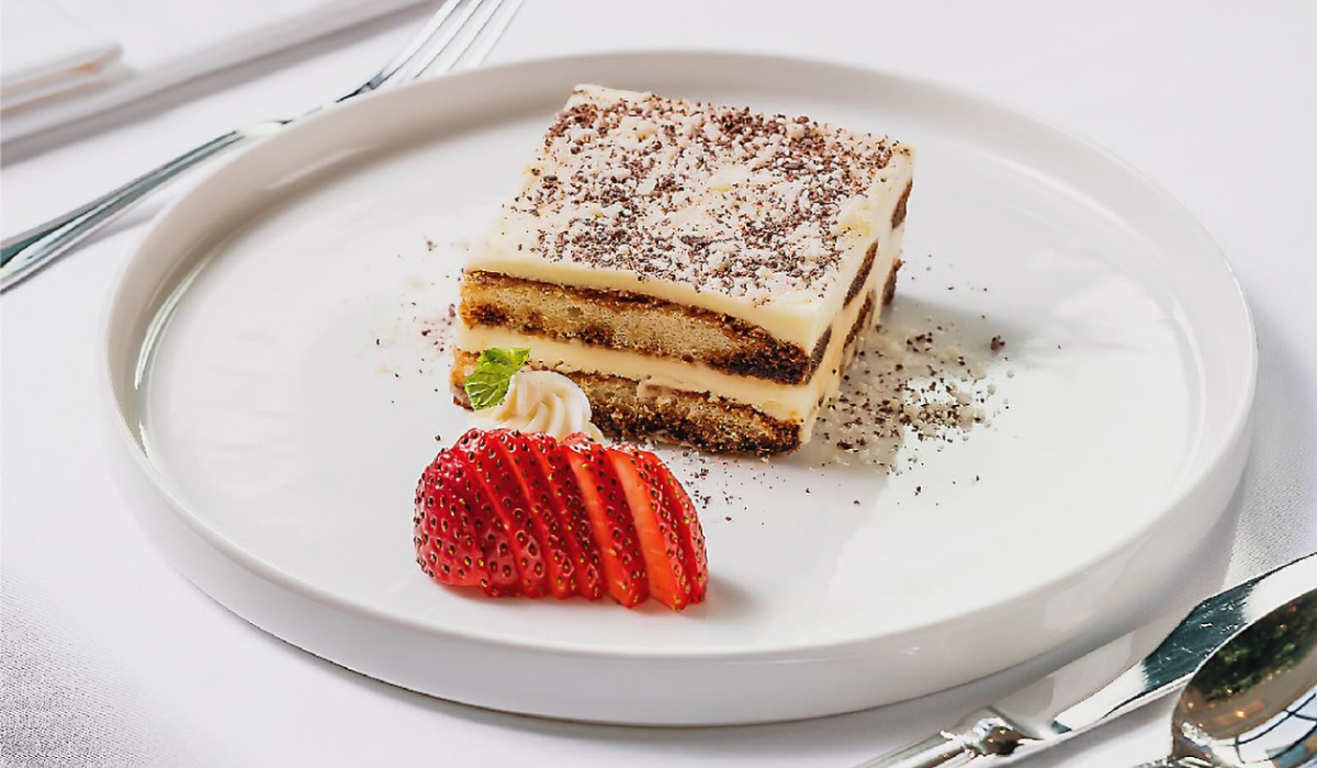 Classic Italian tiramisu from Madeo, layered with espresso-soaked ladyfingers and mascarpone, garnished with fresh strawberry slices. (Supplied)