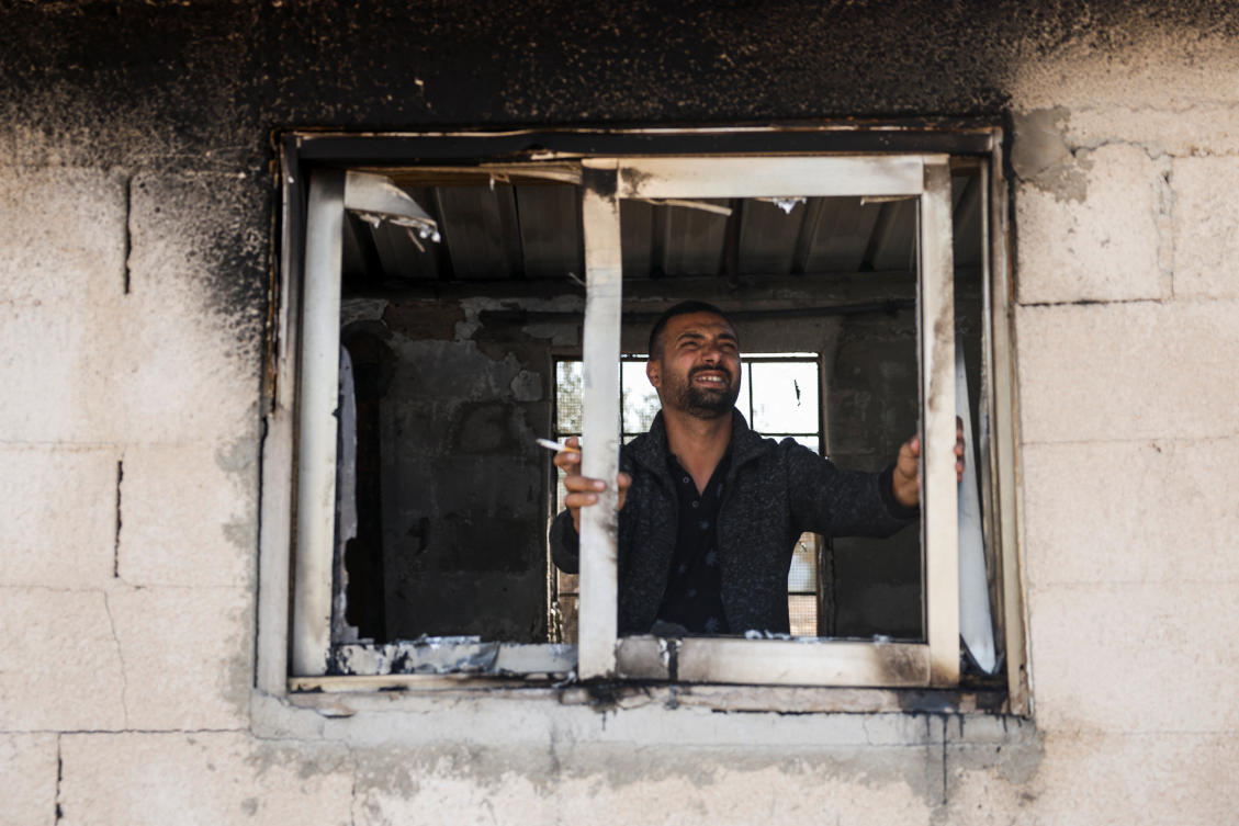 A man looks out from a broken window after an Israeli settler attack on Beit Furik, in the Israeli-occupied West Bank, Nov. 16, 2024. (Reuters)