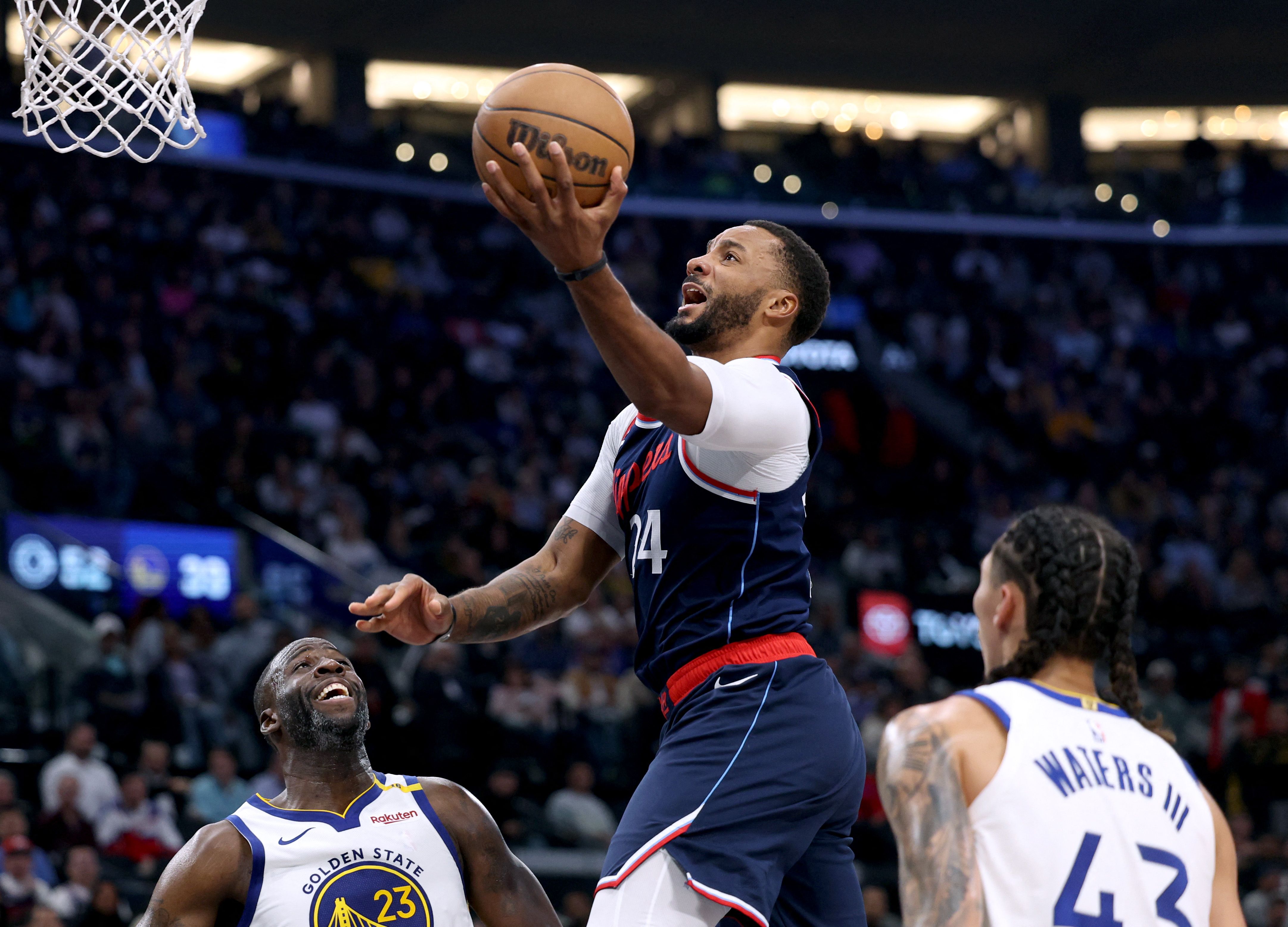 Norman Powell of the LA Clippers scores on a layup in front of Draymond Green and Lindy Waters III #43 of the Golden State Warriors during the first half of an NBA game at Intuit Dome in Inglewood, California. (Getty Images via AFP)