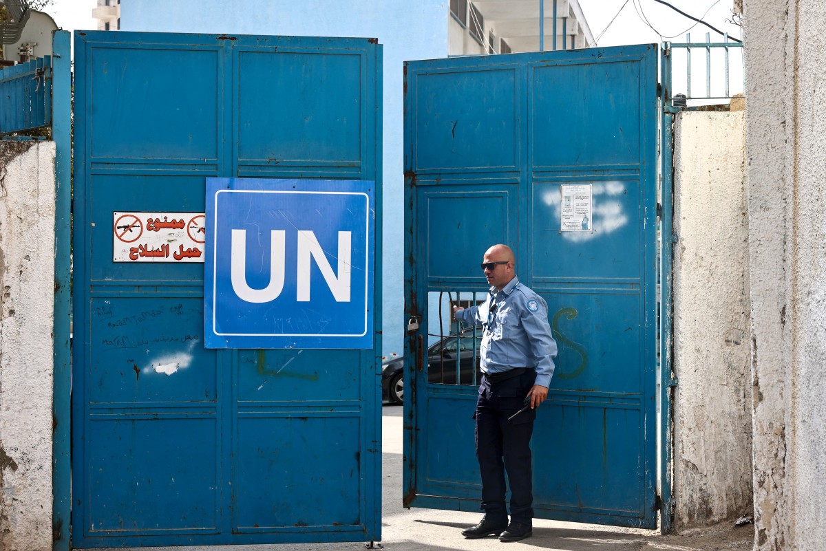A security guard opens the gate at a United Nations Relief and Works Agency for Palestine Refugees (UNRWA) run school in the Qalandia refugee camp in the occupied West Bank on November 14, 2024.(AFP)