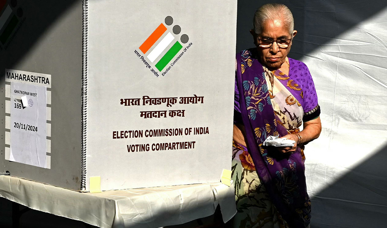 A voter leaves after casting her ballot to vote at a polling booth during the Maharashtra state assembly elections in Mumbai on November 20, 2024. (AFP)