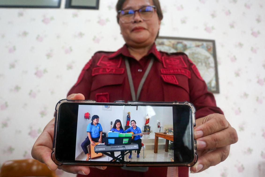 An Indonesian penitentiary officer shows a recent photo of Filipino death row inmate Mary Jane Veloso, center, playing a keyboard ahead of Christmas celebrations on Nov. 21, 2024. (AFP)