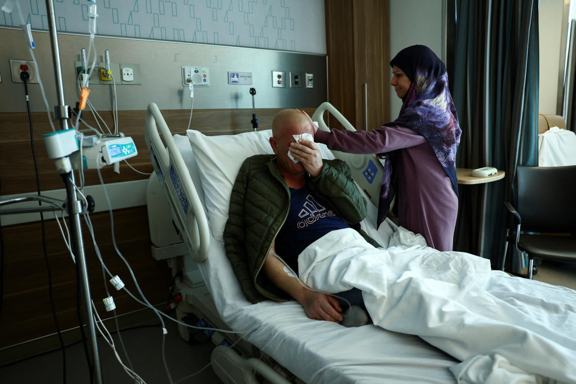 Ahmad Fahess, a sarcoma cancer patient who is displaced from the southern Lebanese town of Nabatieh, is comforted by his sister Majida as he receives treatment at the American University of Beirut Medical Center (AUBMC) in Beirut, Lebanon November 20, 2024. (Reuters)