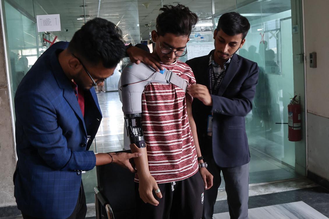 A protester who lost his arm in July’s students’ revolution tries out a prosthetic arm in Dhaka on Nov. 21, 2024. (AFP)