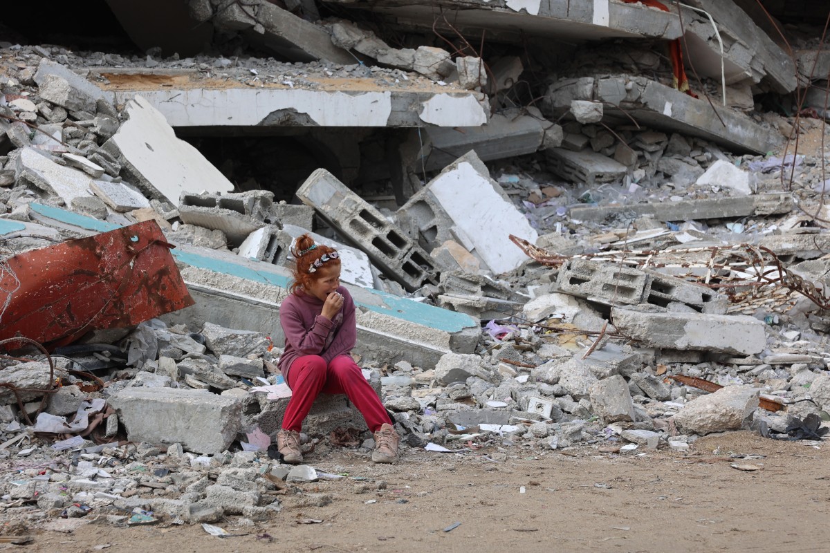 A Palestinian girl rests on the debris of a destroyed building west of Gaza City, on November 25, 2024. (File/AFP)