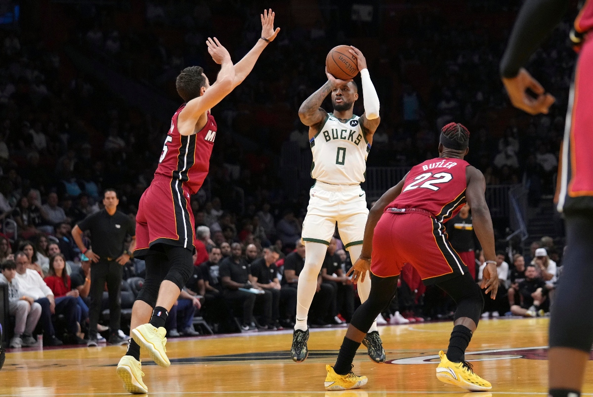 Milwaukee Bucks guard Damian Lillard shoots over Miami Heat forward Duncan Robinson, left, and forward Jimmy Butler (22) during the first half of an Emirates NBA Cup basketball game Tuesday in Miami. (AP Photo/Lynne Sladky)