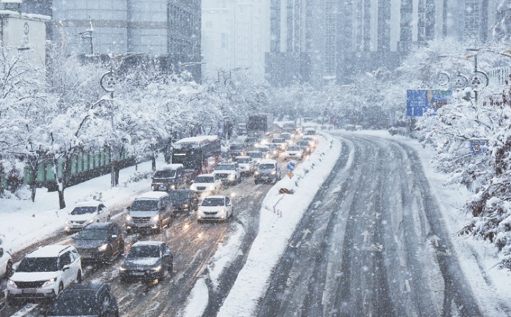 Cars move slowly on a road during heavy snowfall in South Korea. (AP)