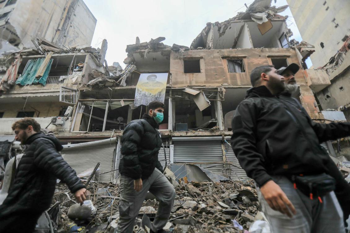 Young Lebanese men check the damage outside a building hit in recent Israeli strikes as people returned to Beirut’s southern suburbs on Nov. 27, 2024 after a ceasefire between Israel and Hezbollah took effect. (AFP)