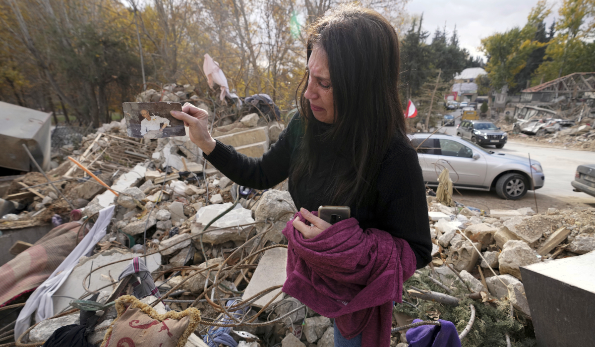 Zeina Rida Jawhari, reacts after recovering a photo of her father from the rubble of her destroyed house in Baalbek, eastern Lebanon, Thursday, Nov. 28, 2024. (AP)