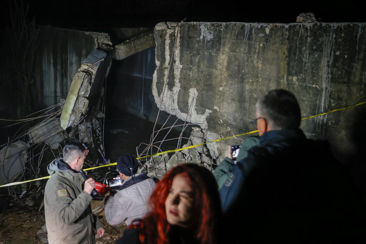 People stand near the damaged canal in Varage, northern Kosovo, on November 29, 2024. (Reuters)