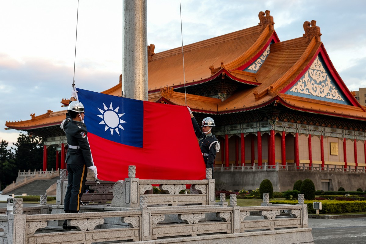 Guards raise Taiwan's national flag on the Democracy Boulevard at the Chiang Kai-shek Memorial Hall in Taipei on November 29, 2024 (AFP)
