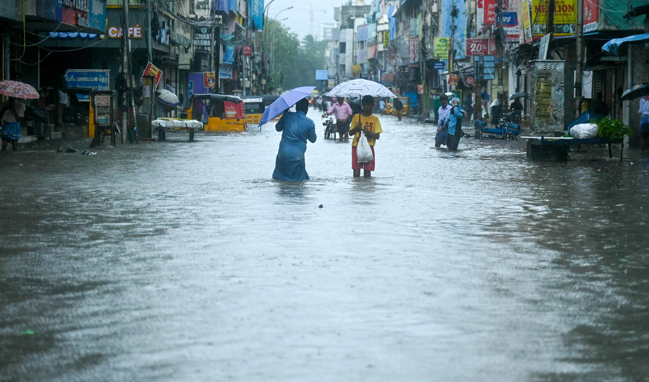 People wade through a flooded street as it rains ahead of a cyclonic storm in Chennai on November 30, 2024. (AFP)