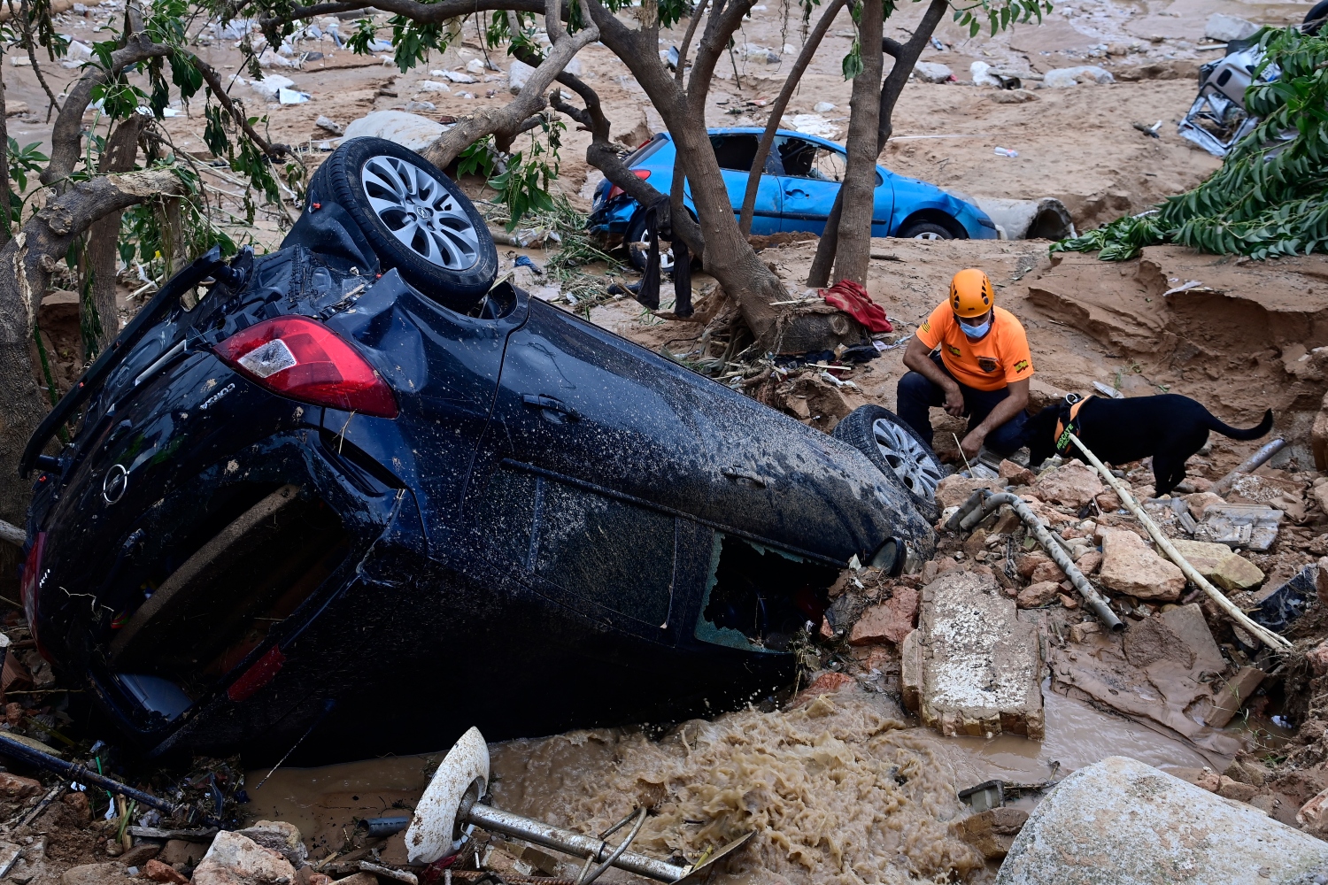A firefighter searches for victims in the half-buried wreckage of a car in the region of Valencia. Nov. 03, 2024 (File/AFP)