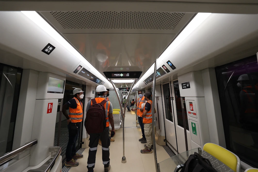 Above, workers onboard a metro line on its way to King Abdullah Financial District station of the Riyadh Metro on April 1, 2021. (AFP file photo)