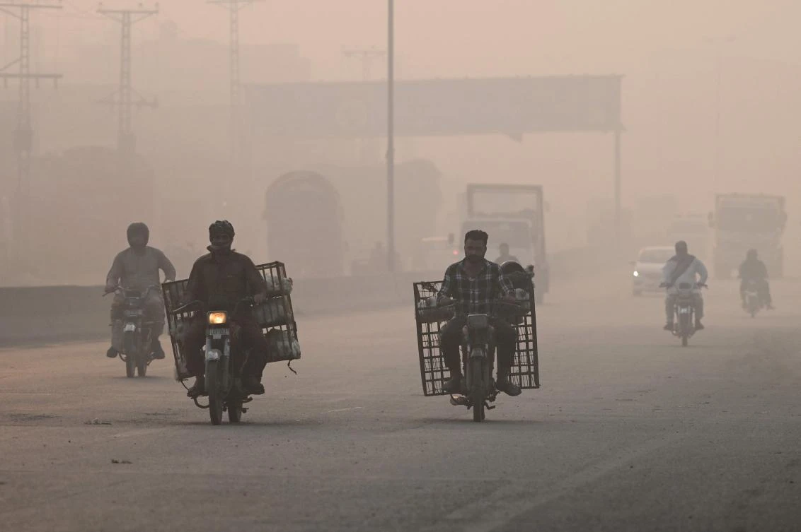 Commuters make their way amid smog in Lahore on November 2, 2024. (AFP)