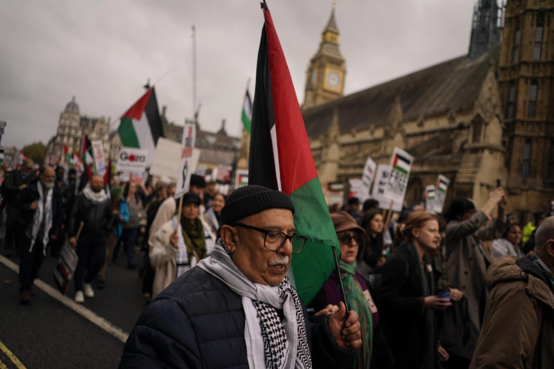 Protesters hold flags and placards during a march in support of the Palestinian people in Gaza, in London, Saturday, Nov. 2, 2024. (AP)