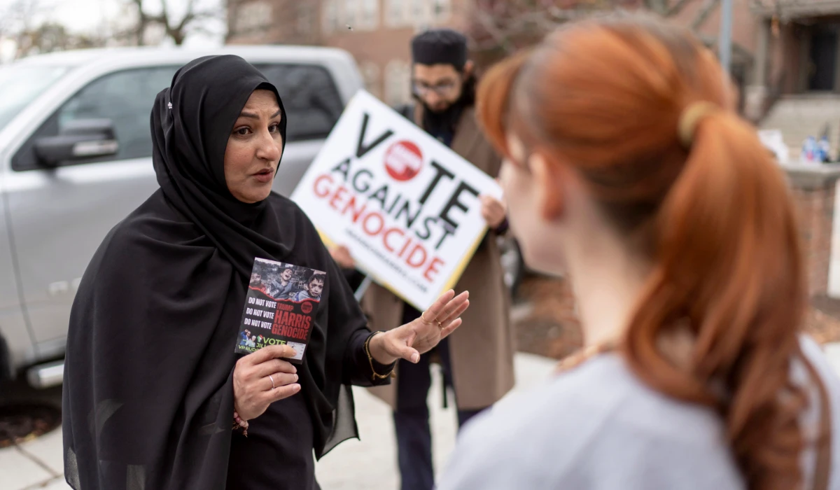 Farah Khan, left, co-chair of the Abandon Harris Michigan campaign, tries to convince Caitlyn Brown to vote for Green Party presidential candidate Jill Stein, Monday, Nov. 4, 2024, in Dearborn, Mich. (AP)