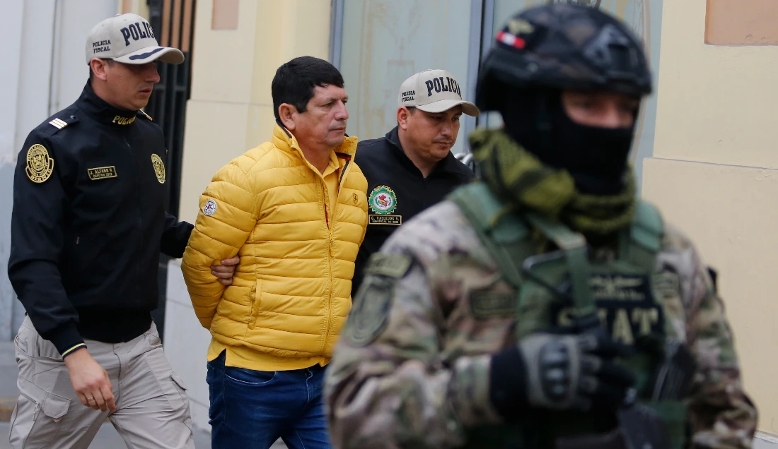 Police escort Agustin Lozano, head of Peru's football federation, after arresting him as part of an investigation into fraud, extortion and money laundering in Lima, Peru. (AP)