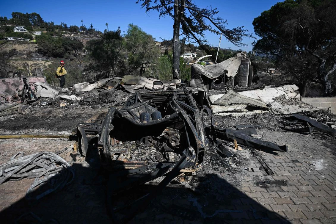 A burned out vehicle sits in the driveway of a home destroyed by a wind driven wildfire on West Highland Drive during the Mountain Fire in Camarillo, California on November 8, 2024. (AFP)