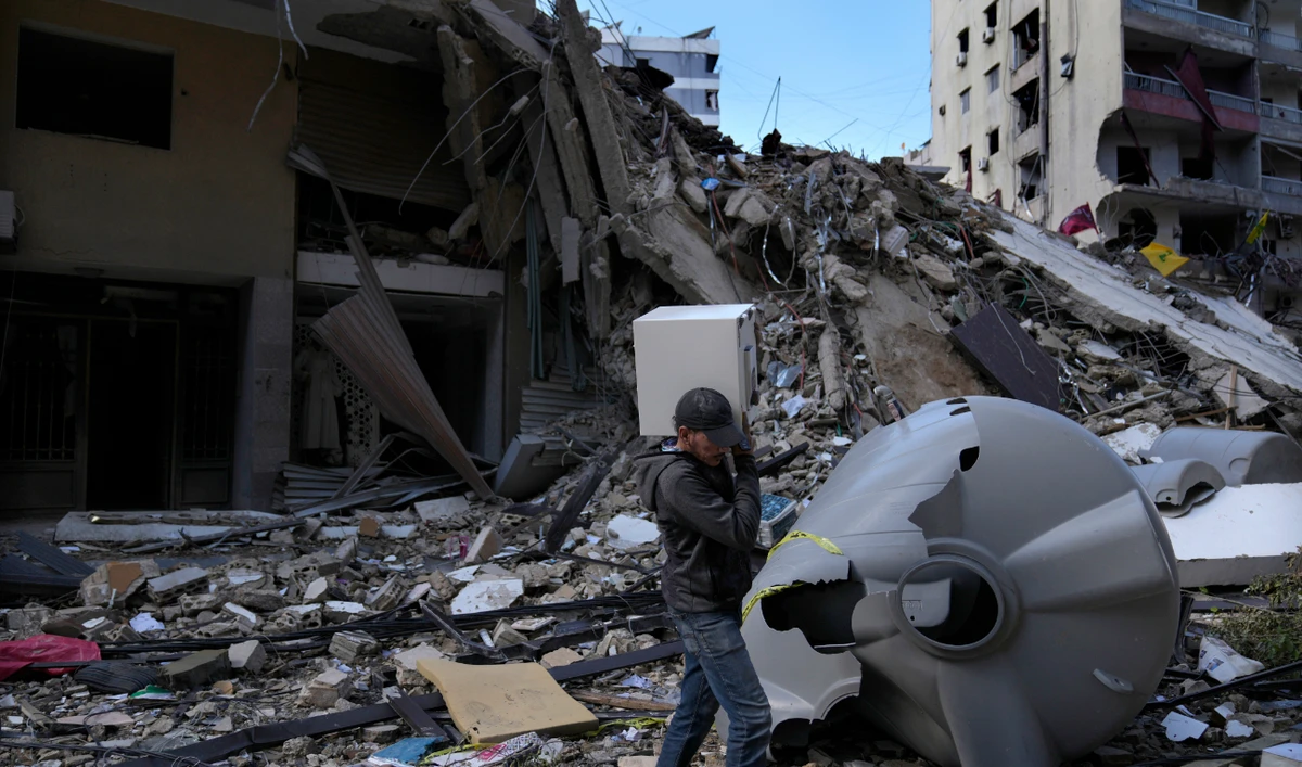 A man carries a safe box after he pulls it out of a destroyed building that was hit by Monday’s Israeli airstrike in Dahiyeh in the southern suburb of Beirut. (AP)