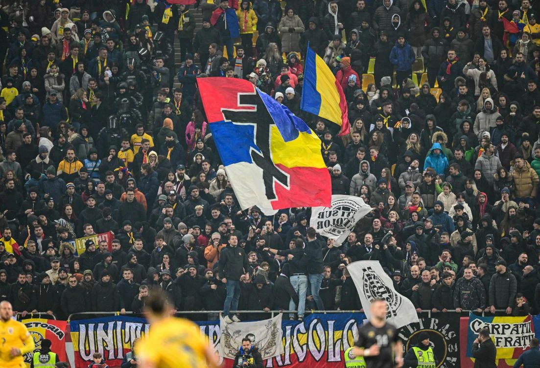 Romanian supporters wave a flag displaying Serbian and Romanian colors united by a Serbian Orthodox cross while chanting “Serbia, Serbia!” before Kosovo’s players left the pitch during their UEFA Nations League, League C, Group 2 match in Bucharest on Nov. 15, 2024. (AFP)