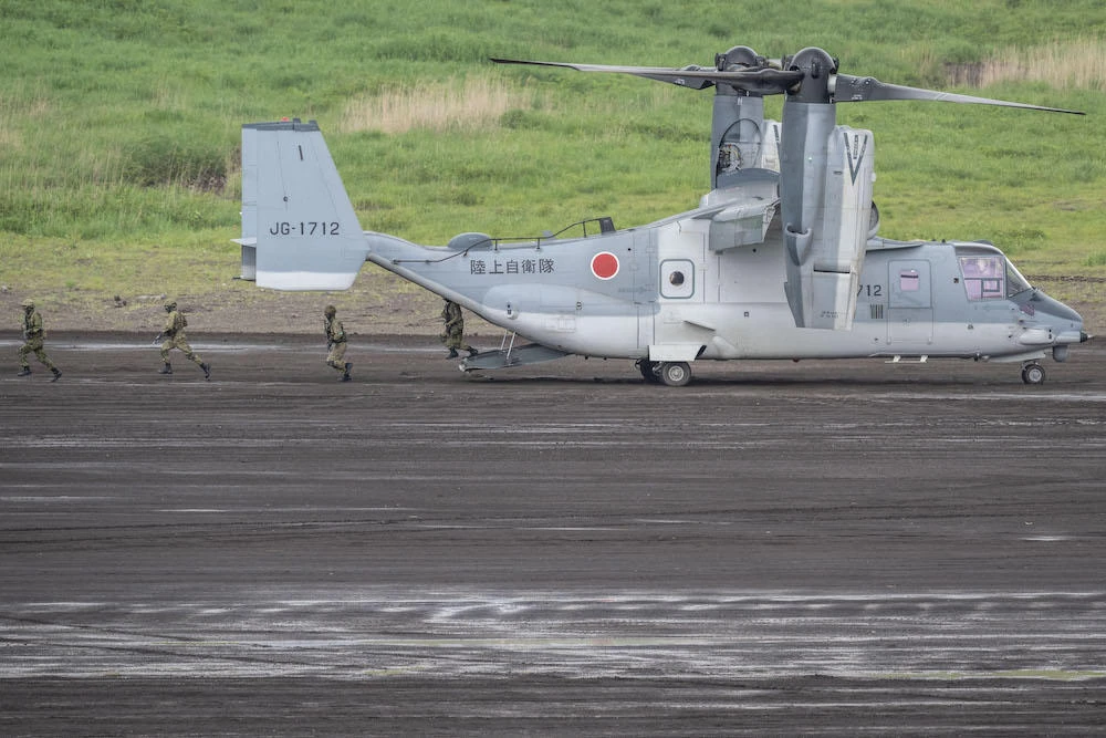 Above, Japan Ground Self-Defense Forces soldiers leave a V-22 Osprey aircraft during a live fire exercise at East Fuji Maneuver Area in Gotemba on May 26, 2024. (AFP)