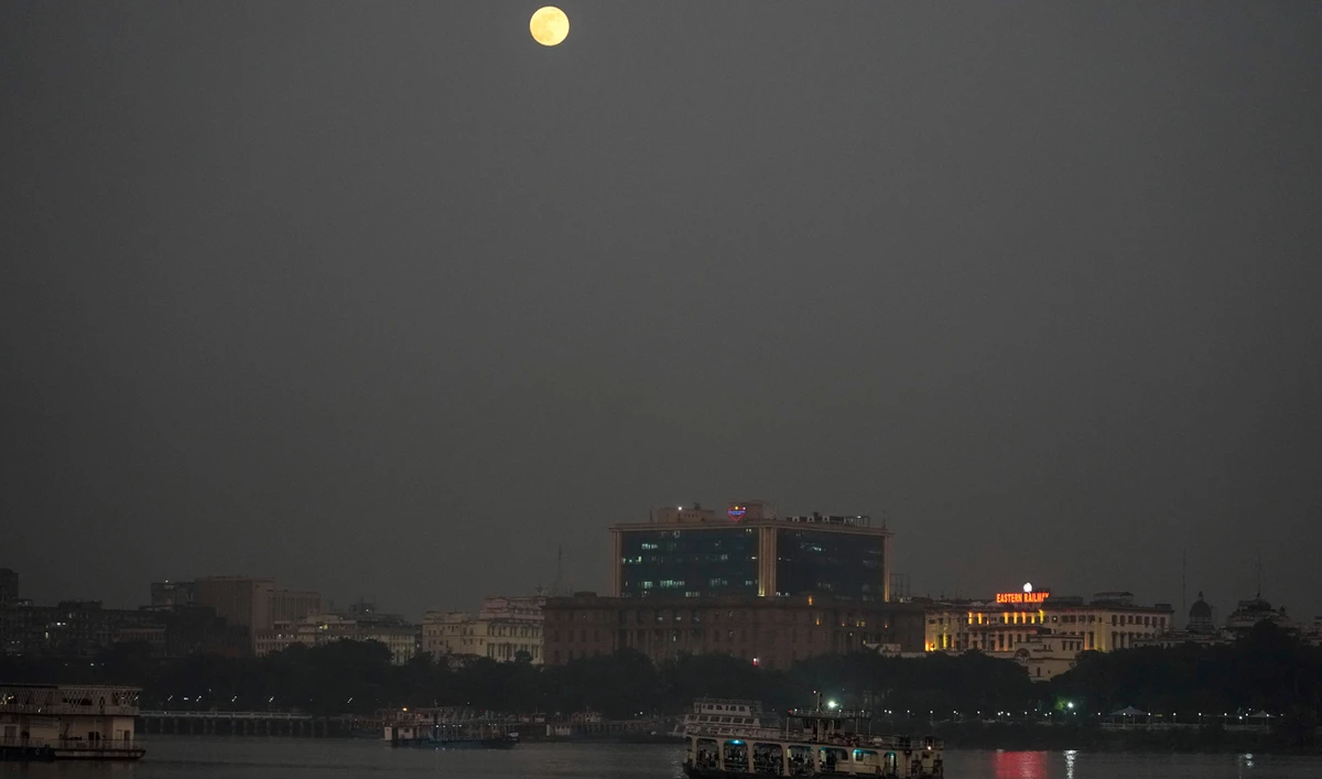 The super moon rises in the horizon as a passenger vessel cross the Hooghly River in Kolkata, India on November 15, 2024. (AP)