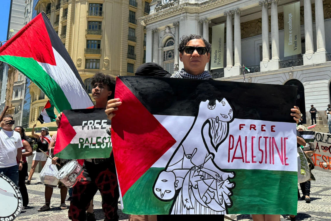 People hold signs during a protest in solidarity with Palestinians in Gaza, amid the Israel-Hamas conflict, during the G20 Summit in Rio de Janeiro, Brazil November 18, 2024. (REUTER)