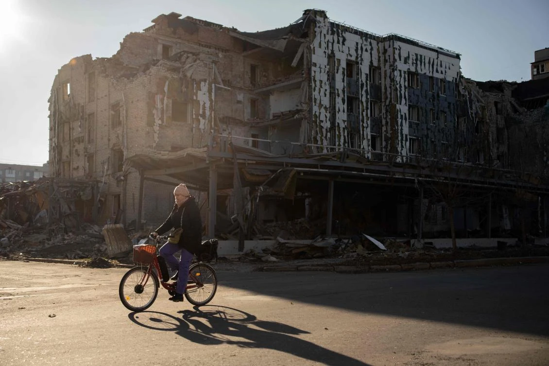 A local resident cycles past destroyed shop and restaurant in the town of Pokrovsk, Donetsk region, on Nov. 19, 2024. (AFP)