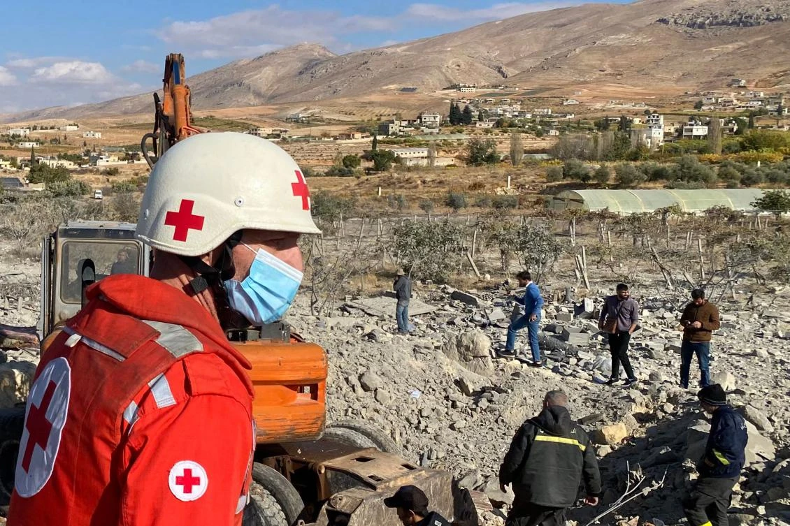 A rescuer from the Lebanese Red Cross looks on as people search the rubble of a building levelled in an Israeli strike in the village of Younine in eastern Lebanon’s Bekaa Valley on Nov. 21, 2024. (AFP)