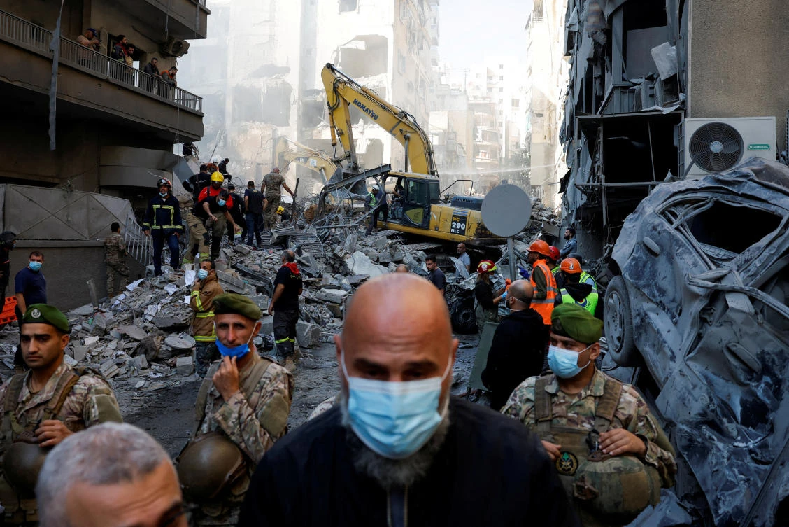 Civil defense members work as Lebanese army soldiers stand guard at the site of an Israeli strike in Beirut’s Basta neighborhood on Nov. 23, 2024. (Reuters)