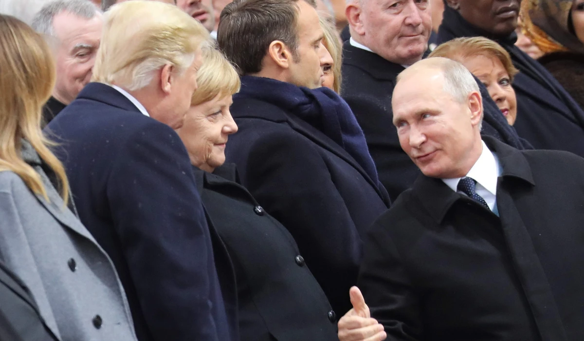 Russian President Vladimir Putin (R), talks with German Chancellor Angela Merkel (C) and US President Donald Trump as they attend a ceremony at the Arc de Triomphe in Paris on November 11, 2018 as part of commemorations marking the 100th anniversary of the 11 November 1918 armistice, ending World War I. (AFP)