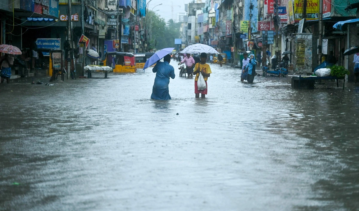 People wade through a flooded street as it rains ahead of a cyclonic storm in Chennai on November 30, 2024. (AFP)