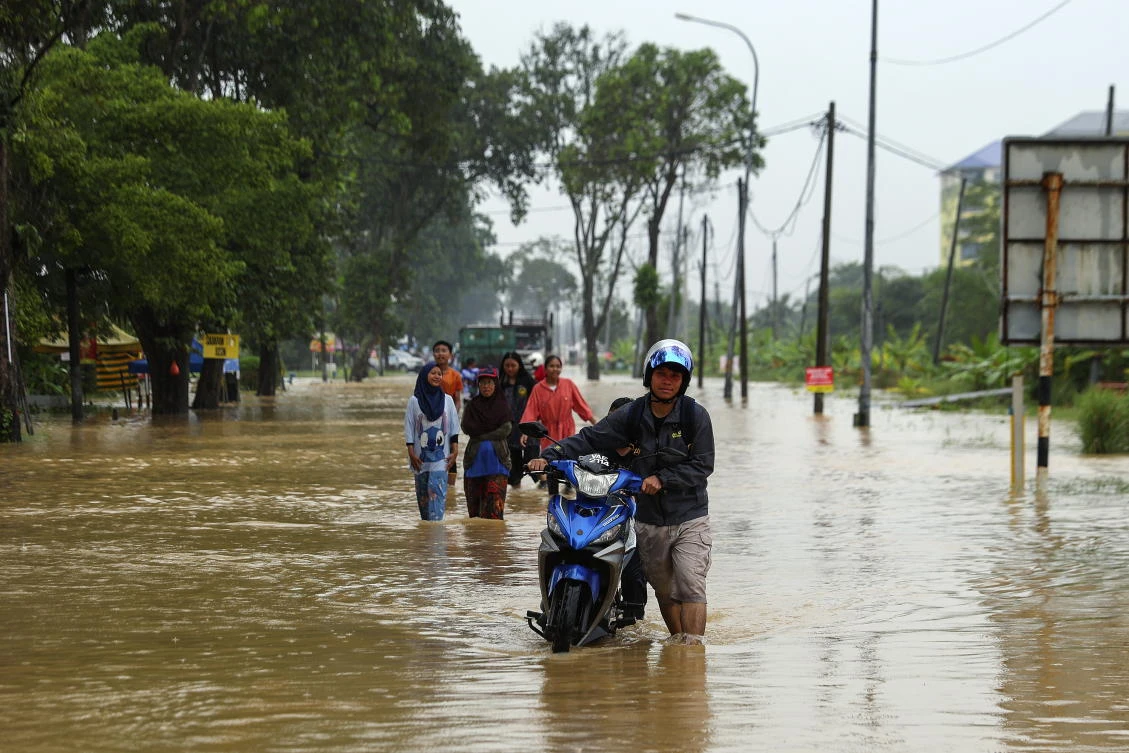A man pushes his motorcycle as he wades through a flooded area in Klang, state of Selangor, Malaysia, 29 November 2024. According to the National Disaster Control Center (NDCC) report of the National Disaster Management Agency (NADMA), over 84,500 people have been displaced due to the floods nationwide, while four deaths have been recorded across the states of Kelantan, Terengganu and Sarawak. (EPA/FAZRY ISMAIL)