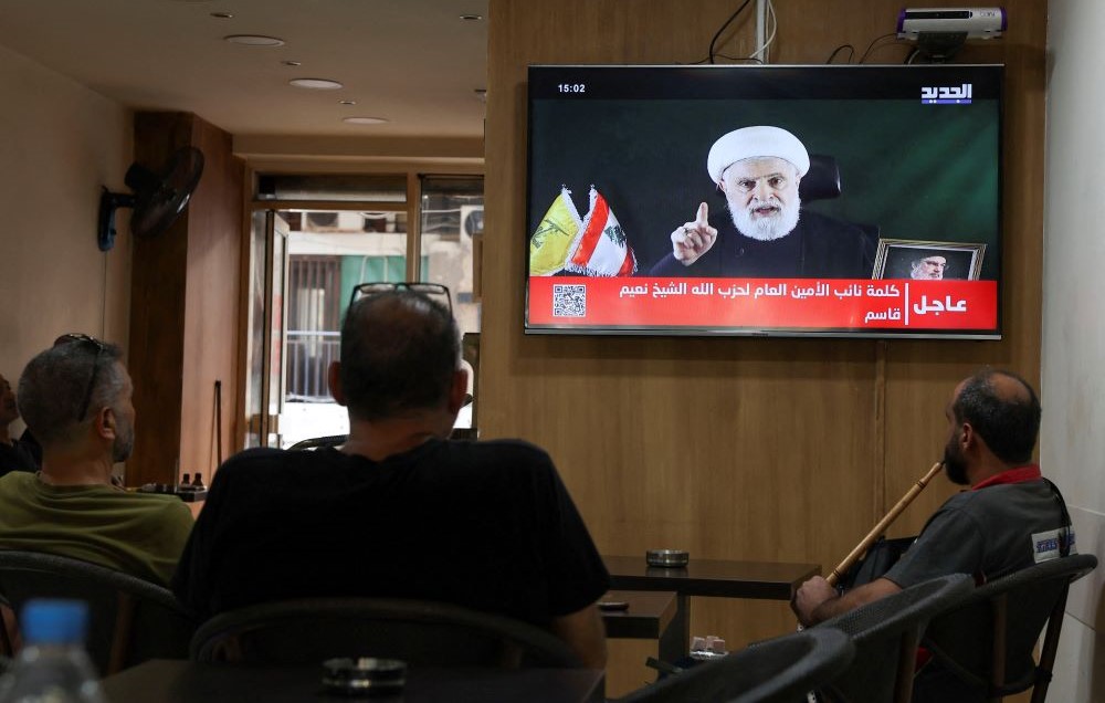 People watch a televised address by Sheikh Naim Qassem, Beirut, Lebanon, Oct. 15, 2024. (Reuters)